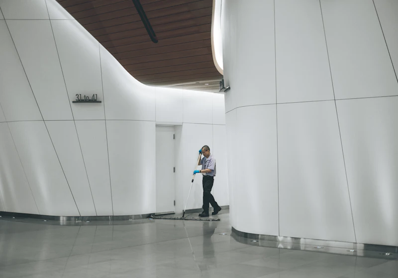 Cleaning staff mopping the floor of a modern commercial building